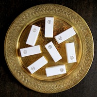 a gold plate with five white squares on it