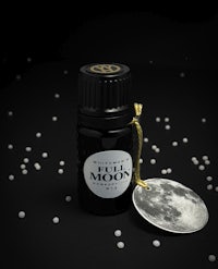 a bottle of moon essential oil on a black background