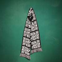 a black and white qr code scarf hanging on a green wall