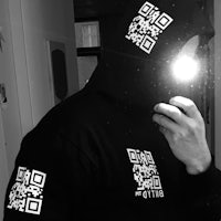 a man wearing a black hoodie with a qr code on it