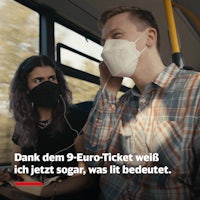 a man and woman wearing face masks on a bus